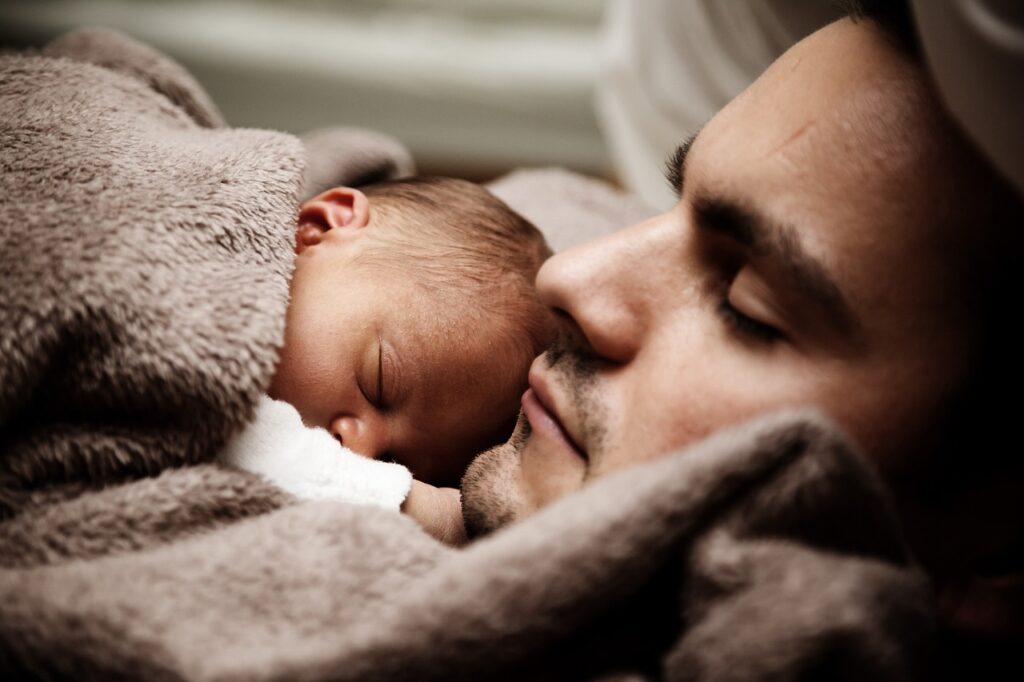 Baby schläft gemütlich beim Vater Warum sind manche Babys so pflegeleicht