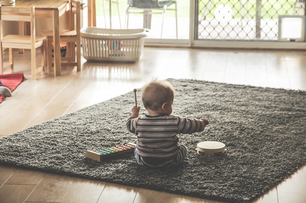 Baby spielt im Wohnzimmer auf dem Boden Warum sind Lauflernwagen schlecht