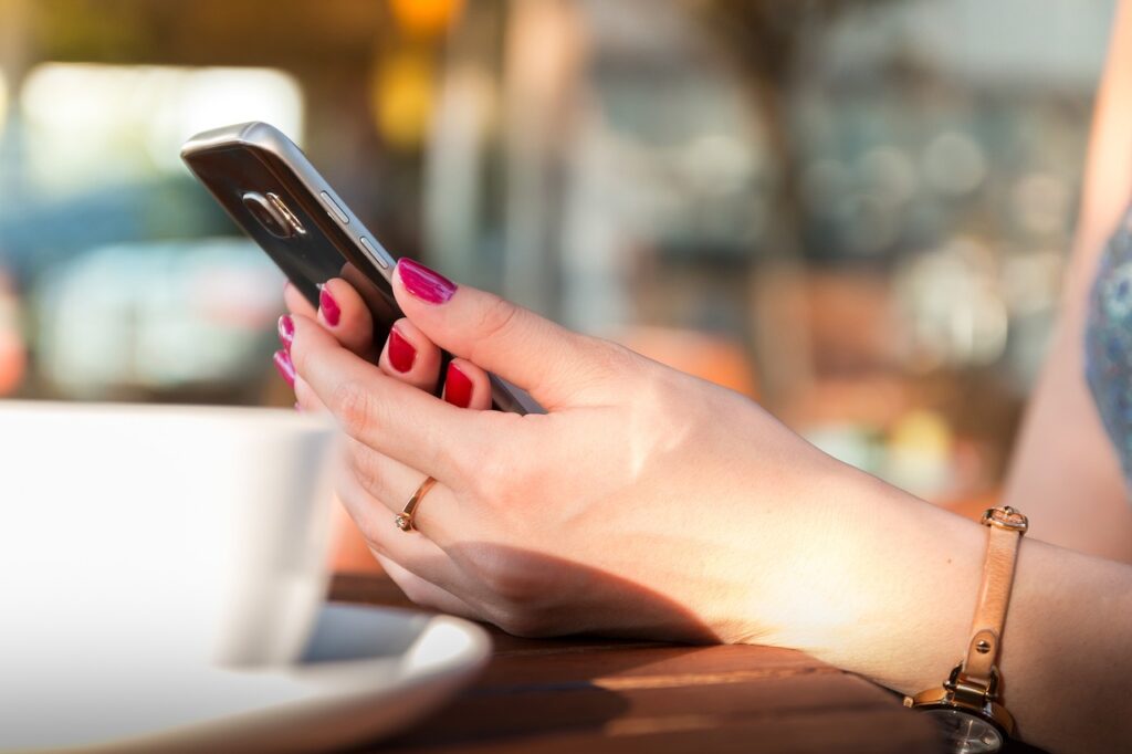 Frau Cafe Smartphone in Hand Trendprodukte unserer Zeit