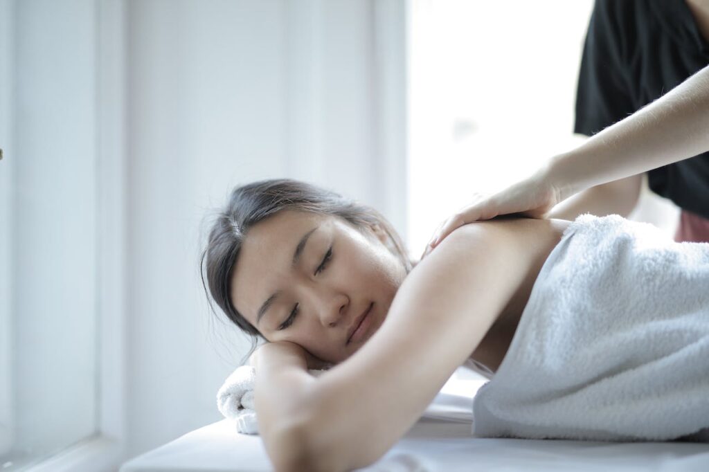 junge Frau entspannt sich bei Massage Massagestab Das sollten Sie darüber wissen!