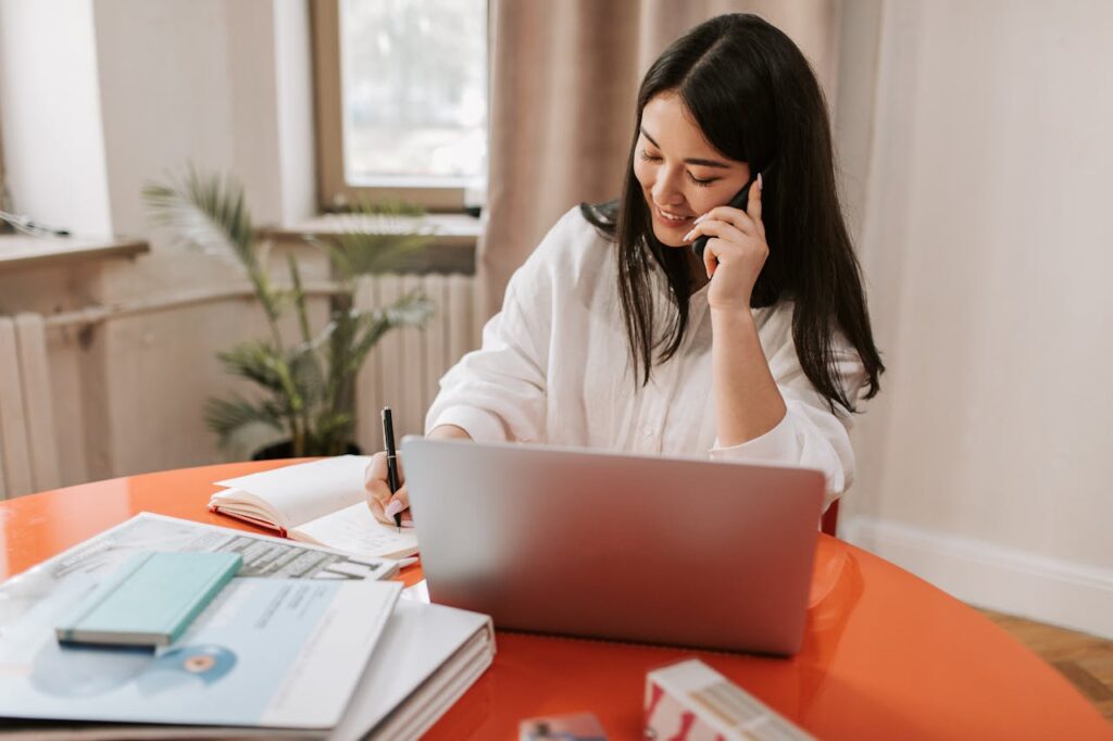 Frau arbeitet am Laptop beim Telefonieren Workflow-Automatisierung Was steckt hinter dem Trend